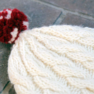 Knit an adorable cable knit beanie for winter with this free pattern.