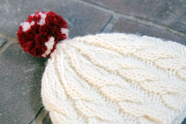 Knit an adorable cable knit beanie for winter with this free pattern.