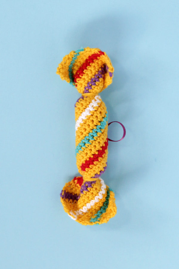 This adorable ornament pulls double duty as a piece of Christmas candy or a British holiday cracker. Whip one up with this free pattern! #crochet #christmascrafts