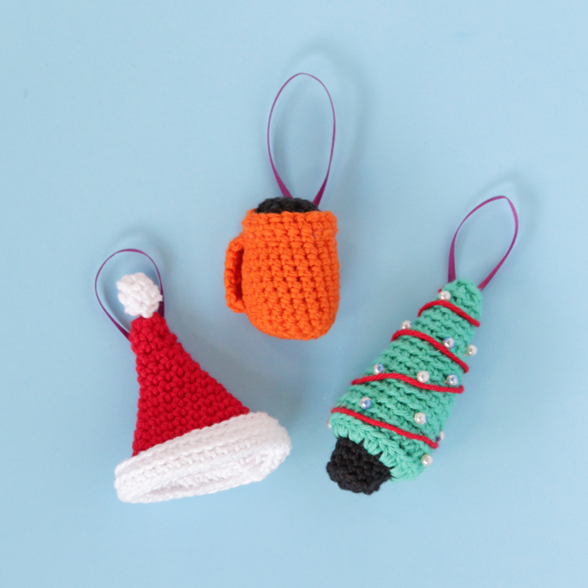 Christmas comes just once a year - celebrate with cute crochet ornaments! Click through for three free amigurumi patterns for a jaunty Santa hat, cheery mug & a sweet mini Christmas tree ornament!