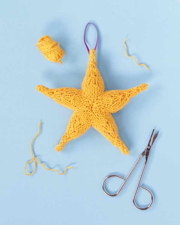 Knit the free pattern for this festive star Christmas ornament.
