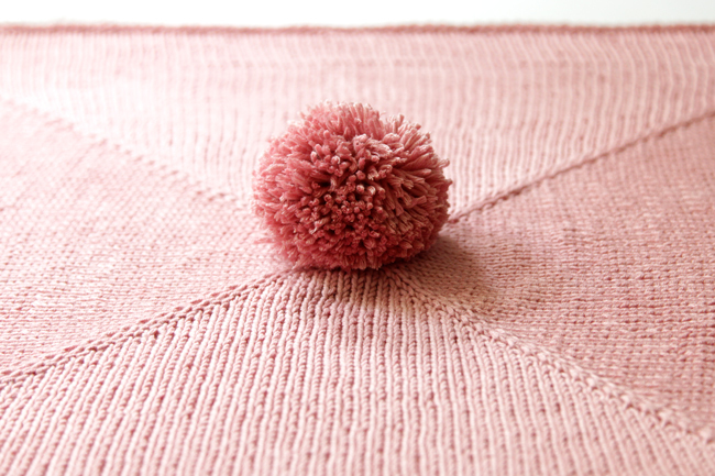 Parlez-vous pom pom? This wee blanket is so adorable, quick and so easy to knit. You'll find yourself cranking out a bunch of these for baby shower gifts galore!