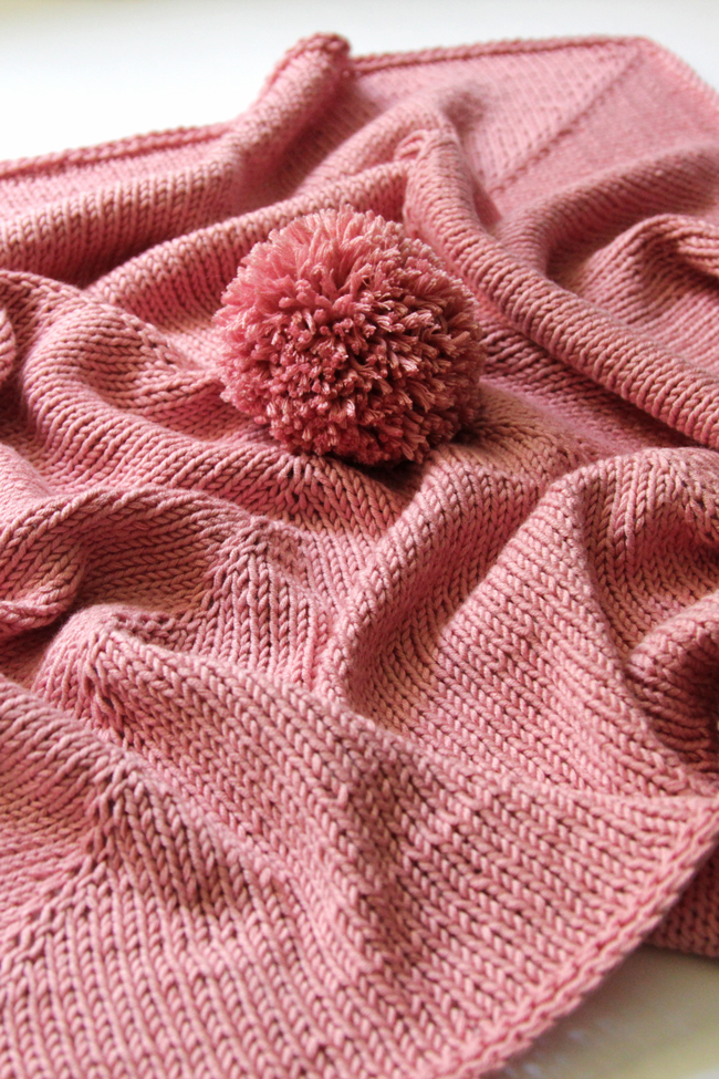 Parlez-vous pom pom? This wee blanket is so adorable, quick and so easy to knit. You'll find yourself cranking out a bunch of these for baby shower gifts galore!