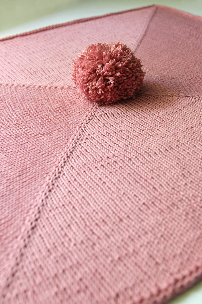 Parlez-vous pom pom? This wee blanket is so adorable, quick and so easy to knit. You'll find yourself cranking out a bunch of these for baby shower gifts galore!