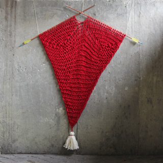 This heart-inspired wall hanging is a fun, quick way for knitters to add a geometric blast of color and texture to your walls without having to master a whole new fiber craft like macrame or weaving. Click through for the free pattern!