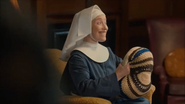 Knitflix for the Holidays - Sister Winifred practicing driving with a crochet pillow in Call the Midwife. 