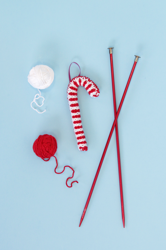 Trim your tree with this free candy cane ornament knitting pattern! Knit flat and seamed, you can quickly make this keepsake ornament with yarn scraps and pipe cleaners.