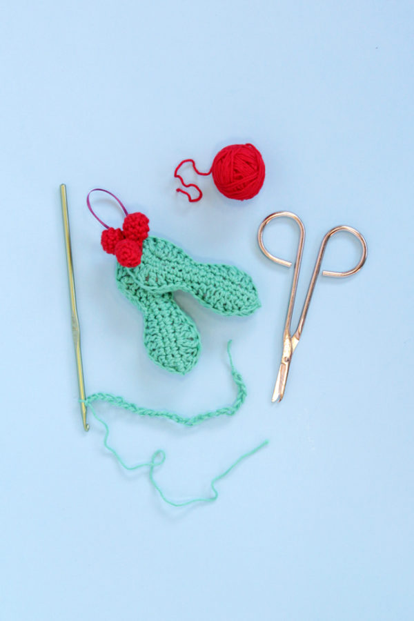 Crochet an adorable holly ornament to hang on your tree for years to come. Get the free pattern for this quick, three dimensional ornament.