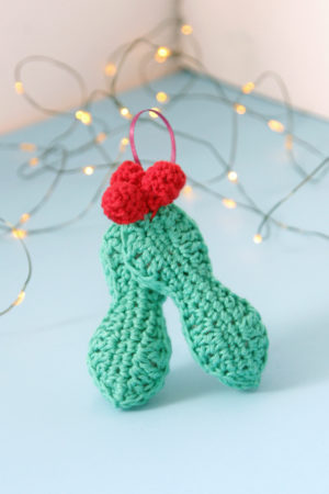 Crochet an adorable holly ornament to hang on your tree for years to come. Get the free pattern for this quick, three dimensional ornament.