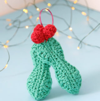 Crochet an adorable holly ornament to hang on your tree for years to come. Get the free pattern for this quick, three dimensional ornament.