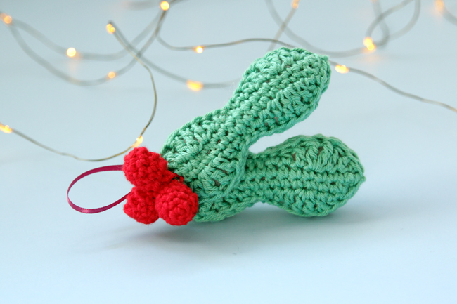 Crochet an adorable holly ornament to hang on your tree for years to come. Get the free pattern for this quick, three dimensional ornament.