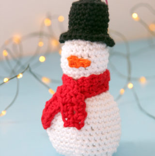 Get a free pattern for this crochet snowman Christmas ornament. Practice your amigurumi skills with this fun pattern!