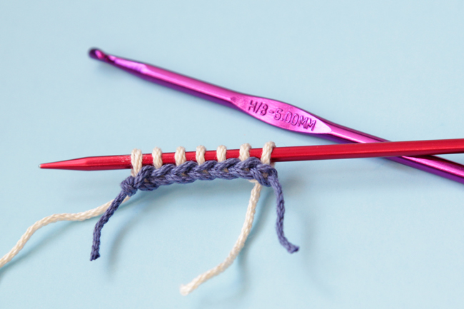 In knitting, a Provisional Cast On lets you access stitches that would otherwise be trapped in the knots of a regular cast on edge. Learn how to do a Provisional Cast On using a scrap yarn method.