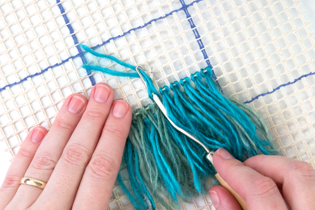 Learn how to latch hook with an easy-to-follow tutorial. Make wall hangings, throw pillows, rugs, and more! Latch hook projects are a great use for scrap yarn too.