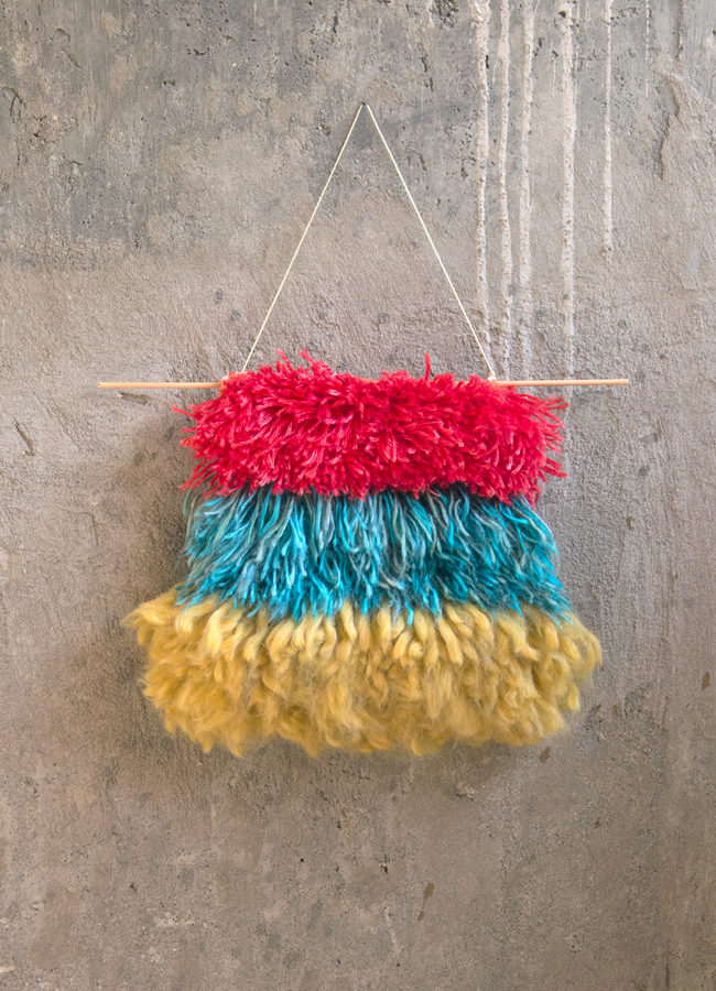 Even beginner crafters can make their own chic wall hanging with latch hook! Get the free pattern for the Primary Tiers Wall Hanging.
