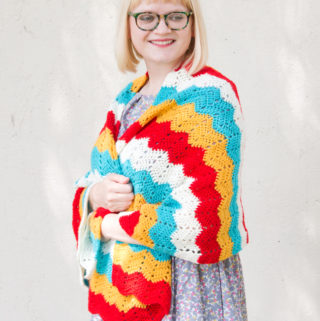 Get your hands on the free crochet pattern for the Ripple Wrap! The Ripple Wrap is a four-color take on one of the most universally-recognized crochet stitches: the ripple stitch. Seen in afghan patterns in grandmothers' houses everywhere, the ripple stitch creates a fun zig zag pattern that opens up tons of possibilities for color combos.