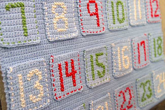Scandinavian Advent Calendar - free crochet pattern -- An advent calendar is a great way to make your own keepsake Christmas decoration and build a family tradition for years to come. The Scandinavian Advent Calendar is great for crocheters at almost any skill level and is inspired by beautiful holiday decor found in Scandinavia. This pattern features basic embroidery stitches for added texture and a handmade look. 