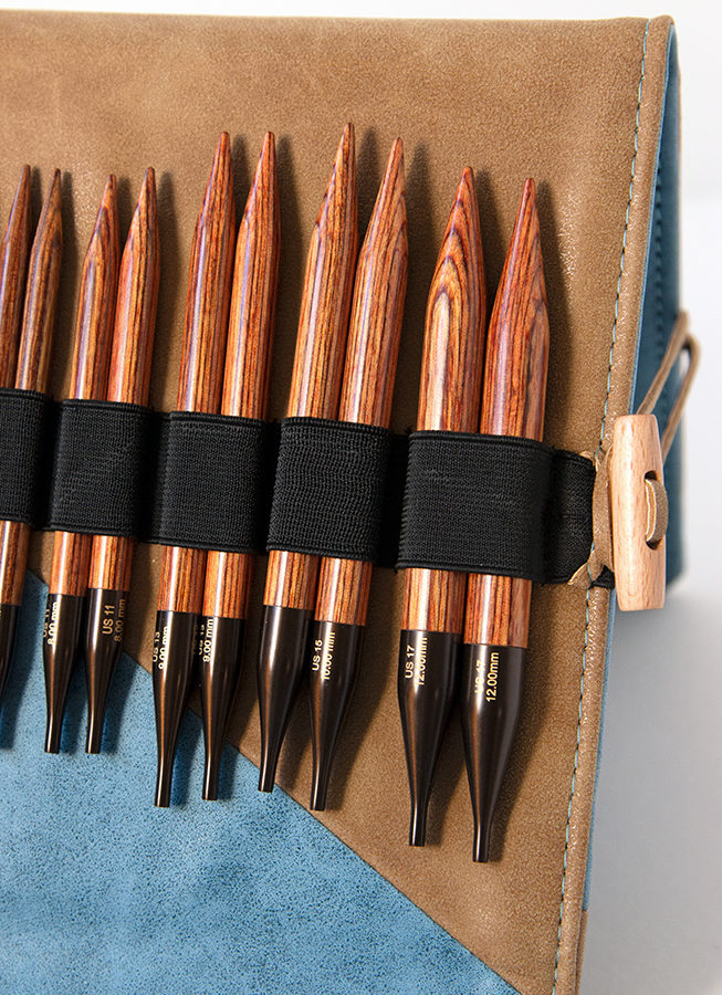 Knitting Needle Review: Knitter's Pride's Ginger Interchangeable Circular Needle sets combine beautiful wood and quality accessories into a thoughtful, practical case. Each set contains 13 set of needles, a wood pen to match, stitch markers, a chart holder, 6 sets of cords, and more. 