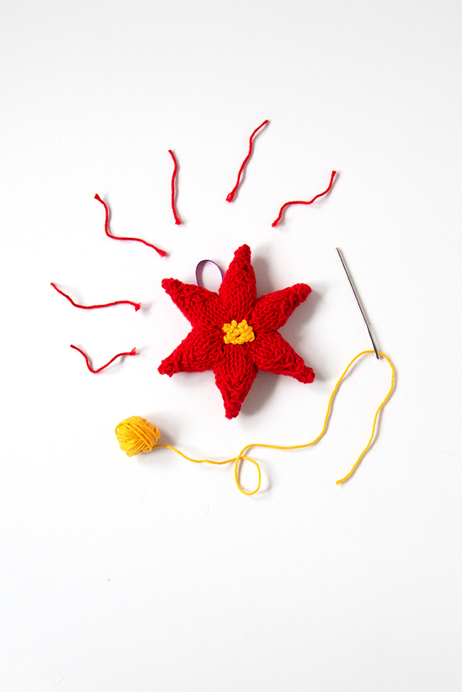 Trim your tree with a hand knit ornament! This festive poinsettia will add a splash of color to your holiday decor. Click through for the free knitting pattern.