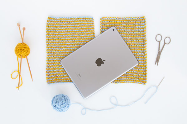 Knit up a simple tablet sleeve to protect your tablet from scratches on the go! The Comfy Tablet Sleeve knits up so quickly, making it a great gift-giving idea too. Get the free knitting pattern.