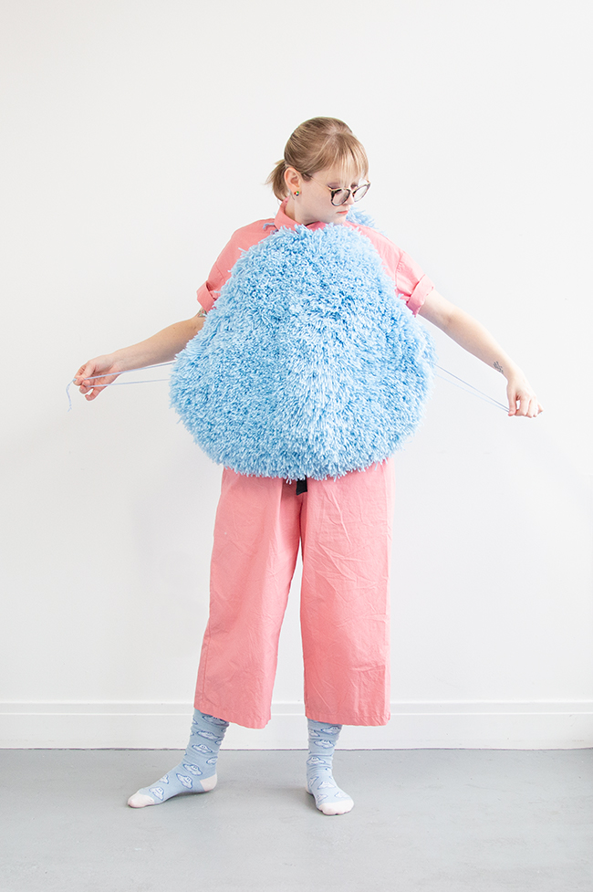 I got this wild idea to make a giant pom pom costume using latch hook, so I gave it a go for Halloween. Take a closer look at this three dimensional rug-making project and its construction.