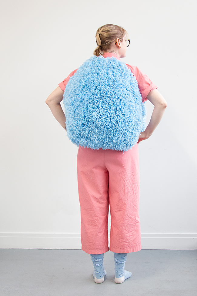 I got this wild idea to make a giant pom pom costume using latch hook, so I gave it a go for Halloween. Take a closer look at this three dimensional rug-making project and its construction.