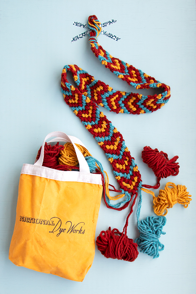 Make a giant friendship bracelet-inspired runner for your Friendsgiving table! Knotted with 100% American wool, this easy project doubles as a hostess gift and macramé scarf. Visit handsoccupied.com to learn how to make this easy Thanksgiving craft project. 