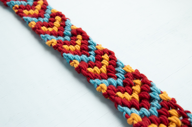 Make a giant friendship bracelet-inspired runner for your Friendsgiving table! Knotted with 100% American wool, this easy project doubles as a hostess gift and macramé scarf. Visit handsoccupied.com to learn how to make this easy Thanksgiving craft project. 