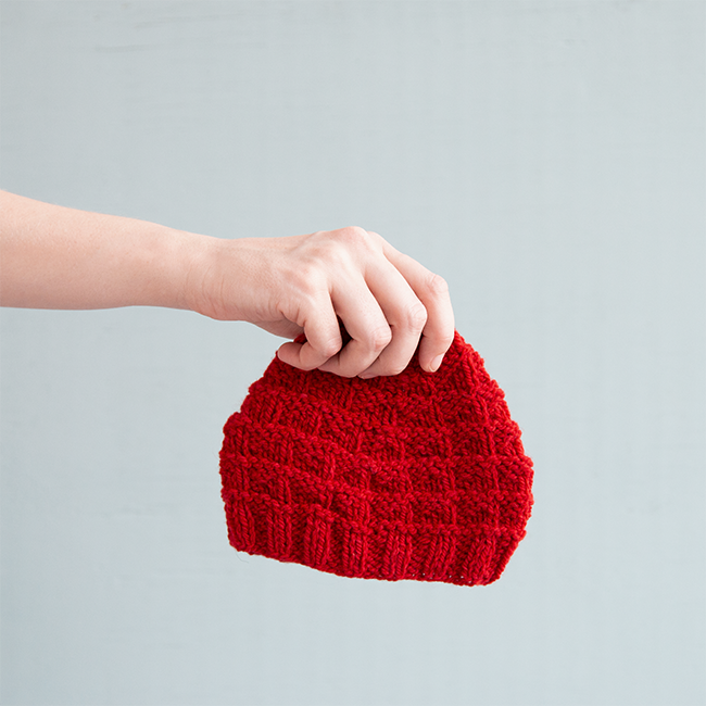 The Triangle Rib Baby Hat knits up so quickly! Get your hands on this free charity knitting pattern for babies on Hands Occupied. #charityknitting #freepattern #babyknitting