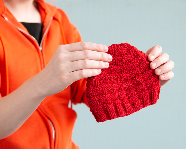 The Triangle Rib Baby Hat knits up so quickly! Get your hands on this free charity knitting pattern for babies on Hands Occupied. #charityknitting #freepattern #babyknitting