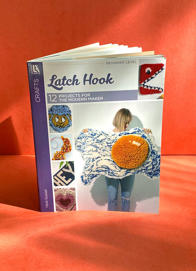 A copy of Latch Hook: 12 Projects for the Modern Maker (2020) by Heidi Gustad on a red background