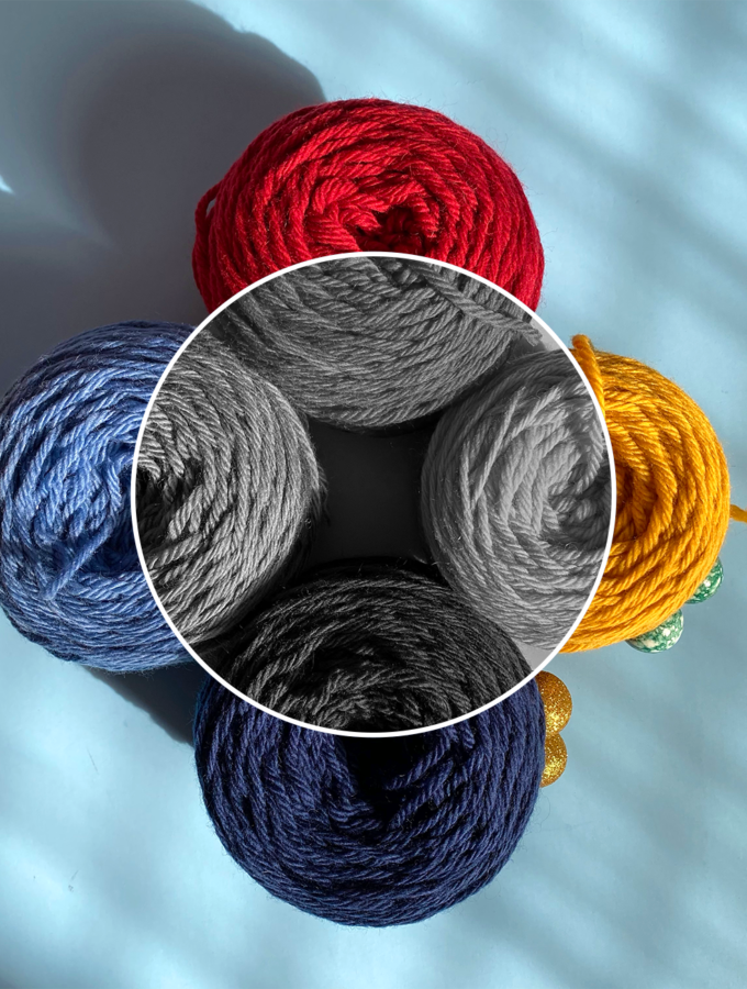 Four skeins of primary colored yarn in color as well as black and white, used to help explain the concept of color value.