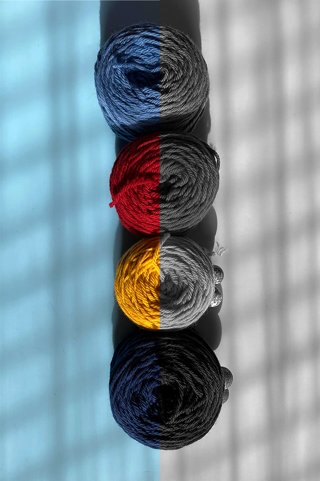 Four skeins of primary colored yarn in color as well as black and white, used to help explain the concept of color value.