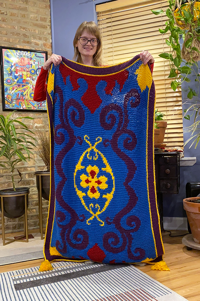 Heidi Gustad (Hands Occupied) after finishing the Magic Carpet Throw Blanket design and sample for Knitting with Disney (Insight Editions, 2021). 